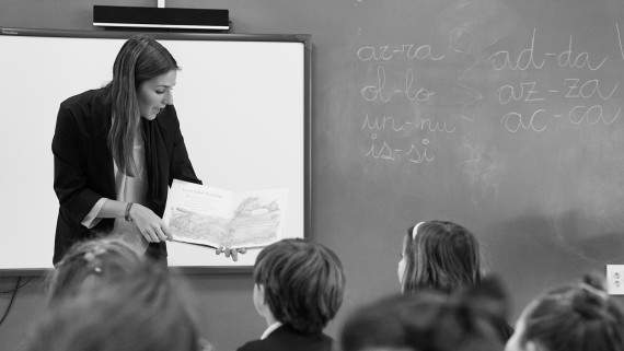 Maestra de educación infantil enseñando a un alumno en una clase